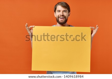 funny bearded man holding yellow mocap poster orange background marketing design