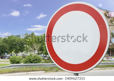 An empty round traffic sign with blue sky in the background.