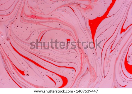 The mixing of the two liquid colors red and pink. Beautiful abstract pink red two color background. Coloring acrylic latex paint