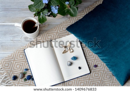 Flat lay top view of work space with notebook & cup of tea of 
turquoise tones
