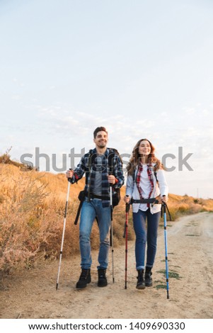 Photo of happy young loving couple outside with backpack in free alternative vacation camping.