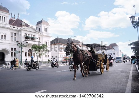 Andong is typical transportation in Jogjakarta city, with the background historycal building Royalty-Free Stock Photo #1409706542
