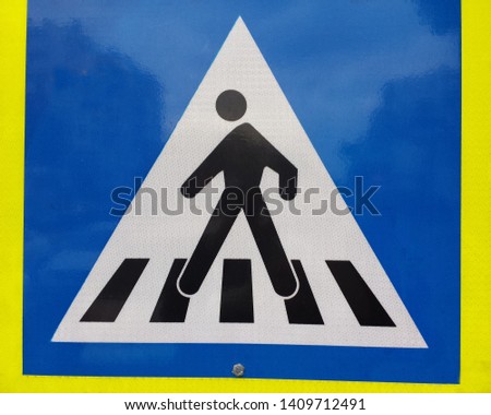 pristine warning pedestrian crossing sign black outline on white with blue and yellow trim