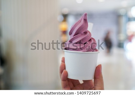 Purple Sweet Potato ice cream soft serve. Woman holding a cup of soft serve ice cream with yogurt sweet potato flavour. (isolated) Royalty-Free Stock Photo #1409725697