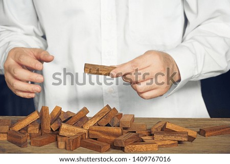 Business 's hand hold wood block with destroy wood block on the table. 