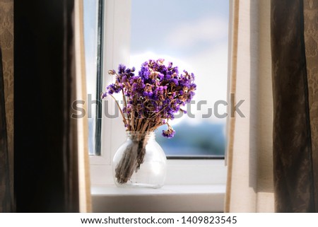 cute lilac wildflowers in a glass jar on a windowsill, background, vintage