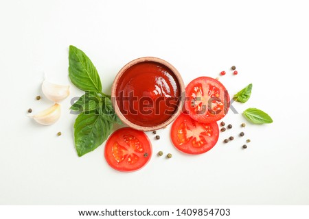 Flat lay composition with fresh cherry tomatoes slices, basil, pepper, garlic and sauce on white background, space for text. Ripe vegetables Royalty-Free Stock Photo #1409854703