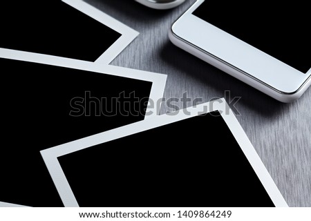 Modern white mobile phone, tablet and paper photo frame on gray background