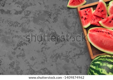 Summer background. Ripe fresh watermelon slices in wooden box on grey concrete table, empty space