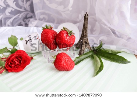 romantic concept. strawberry, flowers and eiffel tower figurine on white background