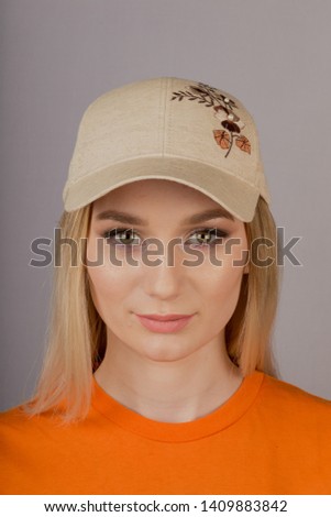 Beautiful girl with natural make-up in a headdress on a gray background.