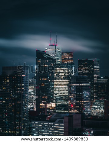 Toronto Financial District City Skyline Skyscrapers with Modern and Historic Building Construction and Development Views at Night with moody storm clouds