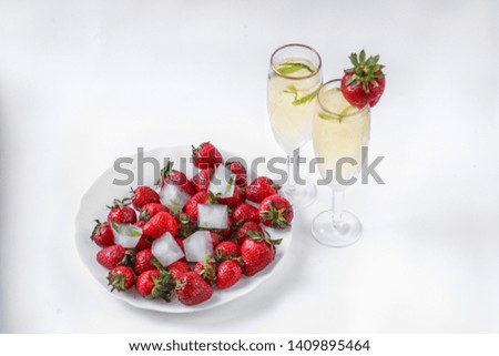 two glasses of champagne and a plate of strawberries