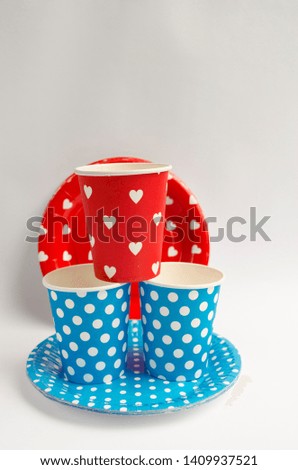 Bright, red and blue plastic picnic dishes. White background. Copy space.