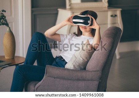 young woman uses virtual reality glasses in beautiful flat