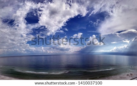Blue skies and clouds over sandy beaches and ocean