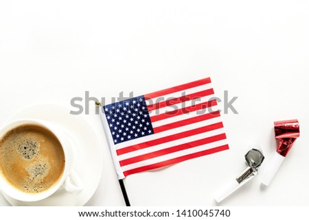 Independence Day USA concept. Memorial Day. Cup of coffee with American flag and noisemakers on white background top view flat lay