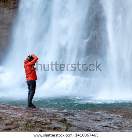 Man Standing Below Virgina Falls Taking Photos