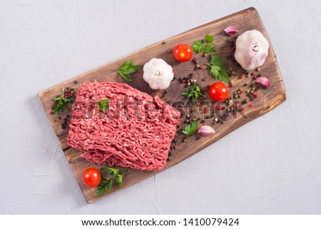 Raw minced beef meat with spices and herbs . Food background