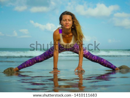 young happy and attractive blond woman doing yoga and meditation exercise outdoors at beautiful beach in relax and flexibility practice outdoors in wellness and healthy lifestyle