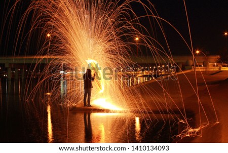 Steel Wool Photography. The picture is clicked using long exposure shot. Beautiful effect is created with lake in the background.