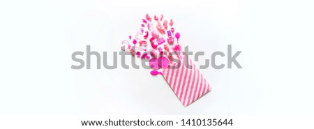 Girly toys for the baby in the pink package. Accessories for dolls. Shoes comb hairpins and varnish. White background