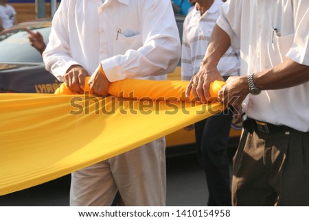 Men are rolling yellow cloth for put on pagoda, Nakhon Si Thammarat Province, Thailand.