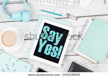 Say yes motivation on digital pad on white wood desk 