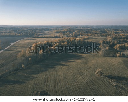 drone image. aerial view of rural area with fields and forests in cloudy autumn day with yellow colored fall trees day. latvia - vintage old film look