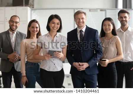 Diverse professional business leaders posing with multicultural workers in office, corporate coaches mentors stand together with employees group, happy staff people looking at camera, team portrait Royalty-Free Stock Photo #1410204461
