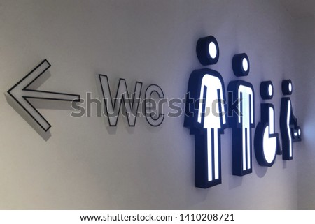 Public restroom signs with a disabled access symbol. Interior of airport terminal or shopping mall. Toilet icons, signs on the wall