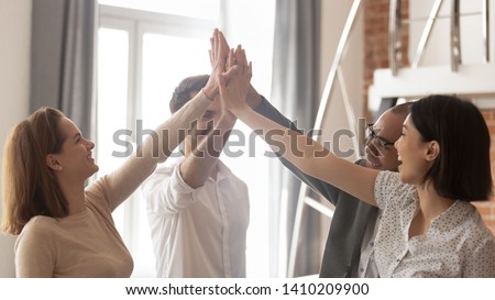 Happy multiethnic employees business team engaged in teamwork teambuilding give high five together involved in celebrating corporate success integrity great professional achievement results in office Royalty-Free Stock Photo #1410209900