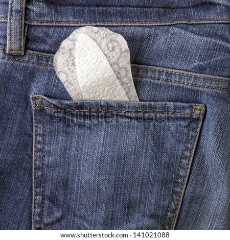 Feminine panties liner in the back pocket of blue jeans