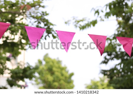 celebrate banner, pink party flags hanging outdoor in the garden