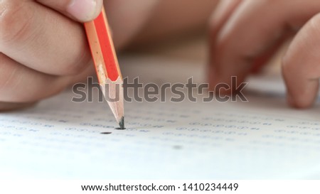 Education test in university or high school concept : Hands student holding pencil for testing exams on answer sheet, taking fill in exam document paper at campus classroom. Knowledge learning concept