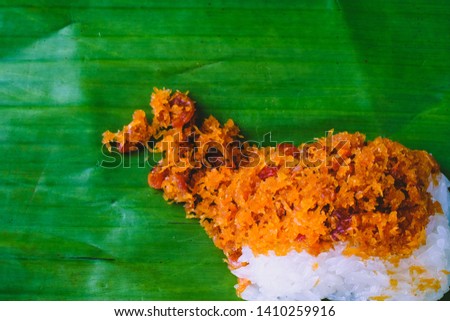 A picture of traditional Thai dessert, sticky rice  with dry shrimps, on banana leaf.