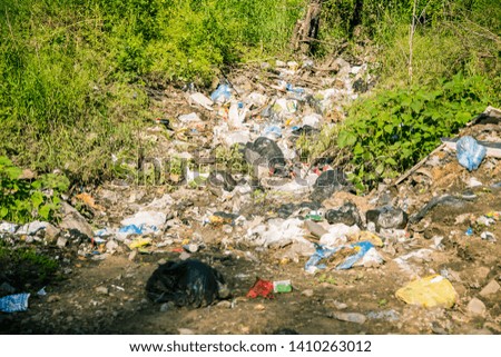 Garbage abandoned by people in nature - plastic packaging, plastic bags, construction waste