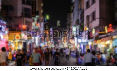 Blurred background of Bui Vien walking street at night illuminated with colorful neon signs. 
