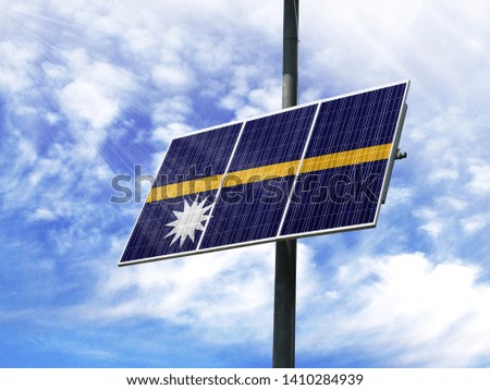 Solar panels against a blue sky with a picture of the flag of Nauru