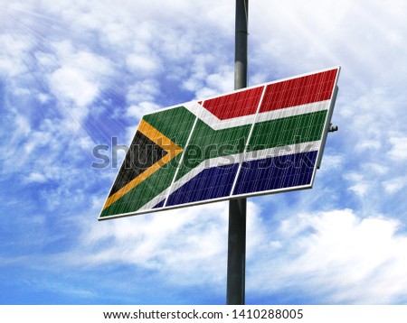 Solar panels against a blue sky with a picture of the flag of South Africa