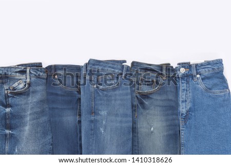Set of different blue jeans isolated on white background top view flat lay. Detail of nice blue jeans. Jeans texture or denim background. Trend clothing. Beauty and fashion, clothing concept.
