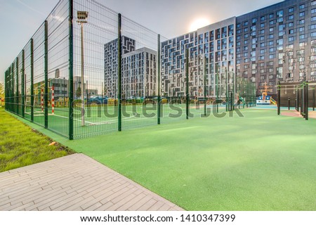 Sports ground in courtyard of residential complex. Public sports grounds for team games of sport, basketball, football, volleyball, handball in residential area, of educational institutions city Royalty-Free Stock Photo #1410347399