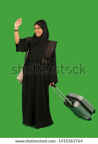 Emirati woman carrying a suitcase Royalty-Free Stock Photo #1410363764