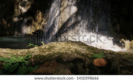 waterfall around stones and rock in the forest