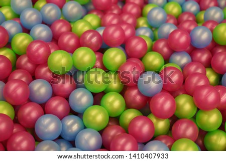 Colorful bright plastic balls from children's play ground. Small toys for leisure. Multicolored pattern design for greeting card, brochure, flyer, banner, poster, postcard. High resolution image. 