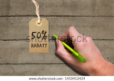 Hangtag with title "50% rebate" in German on wooden background