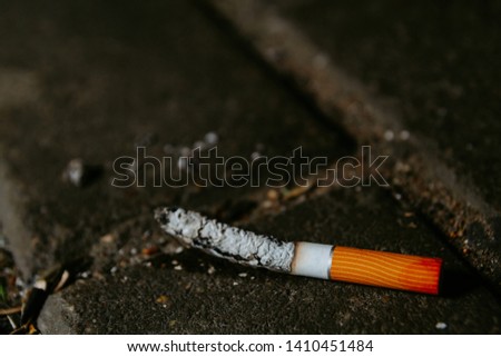 Old smoked cigarette lies on the floor. The concept of nicotine control. World Tobacco Day