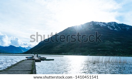 View of Plav Lake and the Plav town in southern Montenegro. Valley and snow peak mountains. Green fields