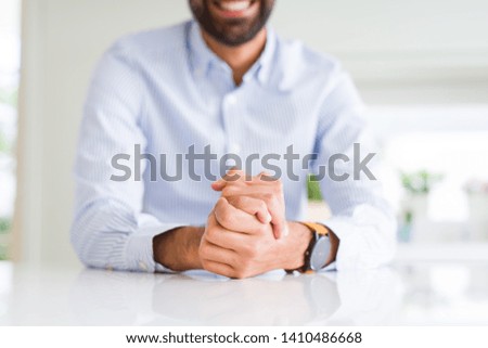 Business man smiling with hands over white table