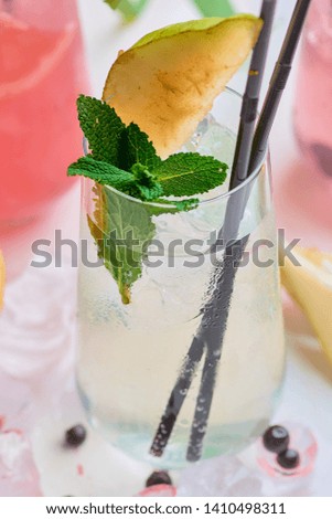 Summer lemonade with ice, grapefruit, pear and berries.